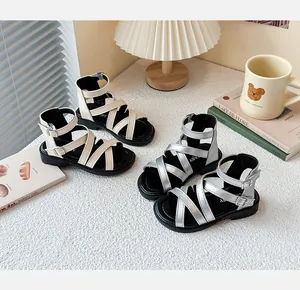 Elegantes sandalias romanas para niñas en color plata y beige en un ambiente acogedor.