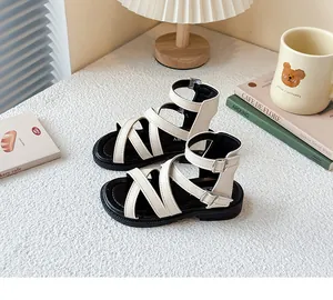 Vista detallada de las sandalias romanas beige para niña con correas cruzadas
