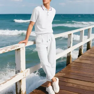 Detail eines weißen Leinensets für Herren mit gestreiftem Poloshirt und Kordelzughose.
