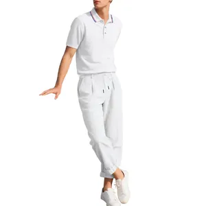 Männliches Modell in weißem Poloshirt und Leinenhose für Business-Casual-Stil