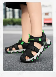 Primo piano di sandali traspiranti da bambino in nero e verde neon per l'estate