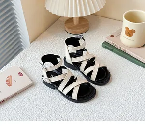 Sandalias romanas beige para niñas con tiras cruzadas y suelas negras para el verano