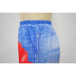 Detailed close-up showing the elastic waistband and red floral print on denim-style wide-leg pants