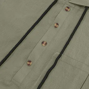 Macro view of a men's linen hooded Henley shirt featuring buttons and black drawstrings.