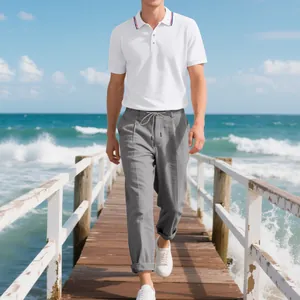 Herren-Set: weißes Poloshirt und graue Leinenhose auf einem sonnigen Strandsteg