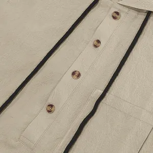 Close-up detail of a linen Henley shirt with black piping and stylish amber buttons.