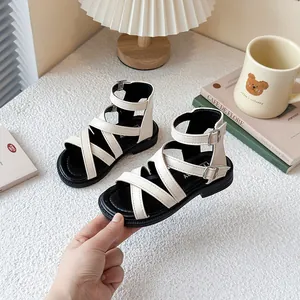 Sandalias romanas blancas para niña con tiras cruzadas y hebillas para verano.