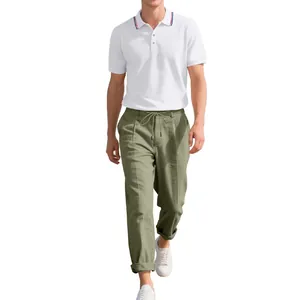 Detailansicht eines sommerlichen Herrenoutfits mit weißem Polo und grüner Leinenhose.
