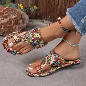 Close-up view of ethnic style flat toe-loop sandals featuring a colorful paisley print
