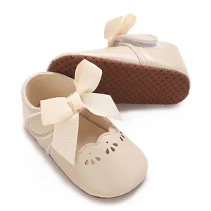 Dettaglio scarpe neonata crema con fiocco grande e suola morbida antiscivolo