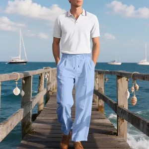 Detail des Herren-Sommer-Sets mit weißem Polohemd und hellblauer Leinenhose auf Steg