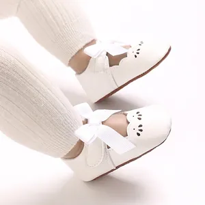Vista dettagliata delle scarpe bianche da principessa per neonata con grande fiocco
