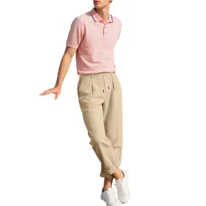 Sommerliches Business-Casual-Set für Herren mit rosa Polohemd und beige Leinenhose.
