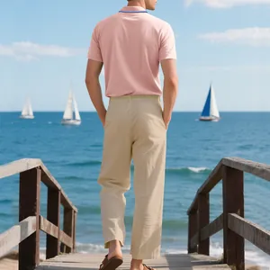 Rückansicht eines Mannes in Poloshirt und Leinenhose auf einem Pier am Meer