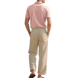 Rückansicht eines Mannes in rosa Polohemd und beiger Leinenhose für den Sommer.