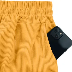 Detail der gelben Cord-Cargo-Shorts mit elastischem Bund und großer Seitentasche.