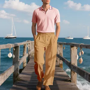 Sommerliches Herren-Set mit rosa Polo-Shirt und khakifarbenen Leinenhosen am Meer