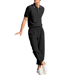 Ganzkörperansicht eines minimalistischen schwarzen Poloshirts und einer Leinenhose für Herren
