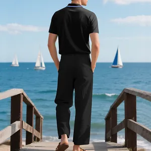 Rückansicht eines schwarzen Herren-Polohemd- und Leinenhosensets am Meer in Freizeitoptik