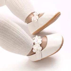 Close-up of white baby girl princess shoes with 3D flower and pearl details