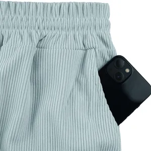 Detailaufnahme der Tasche einer hellblauen Herren-Cordshorts mit einem Smartphone