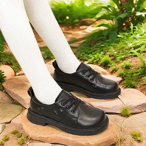 Elegante schwarze Lederschuhe für Mädchen mit Herzbestickung in einer Gartenlandschaft