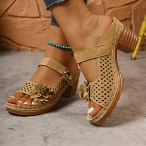Detail view of camel chunky heel slides featuring laser-cut patterns and 3D flower accents.