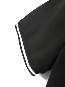 Close-up of black polo shirt sleeve with white striped ribbed cuff detail.