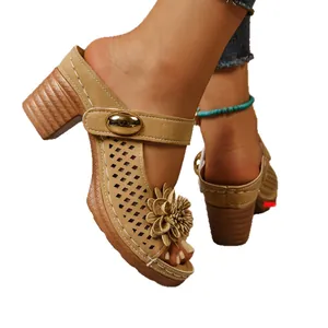 Stylish tan chunky heel sandals featuring a decorative flower and perforated suede straps