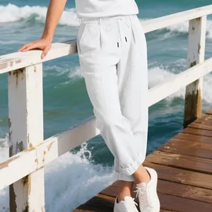 Men's loose white linen-style trousers on a sea pier, breathable summer casual pants