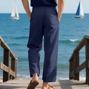 Back view of men's loose navy blue linen trousers for summer vacation on a beach boardwalk