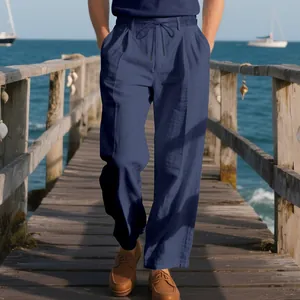 Men's loose navy linen casual trousers with Napolitan pleats on a wooden pier backdrop