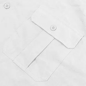 Detalle del bolsillo de parche con botón en una camisa de lino blanca para hombre