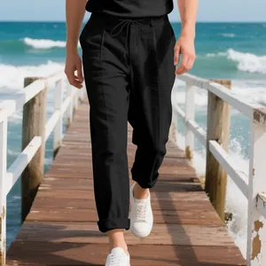Macro view of black linen trousers on a model walking along a wooden beach pier