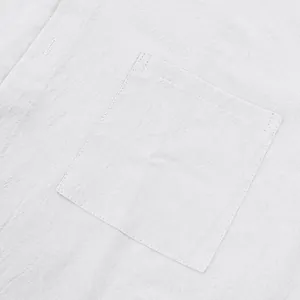 Primer plano del bolsillo del pecho que muestra la textura de lino de la camisa blanca