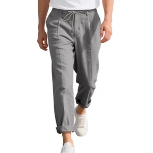 Detail view of men's loose gray linen trousers with drawstring waist and rolled cuffs