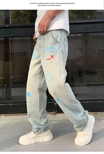 Detail of light blue straight-leg jeans with vibrant blue and red graffiti prints.