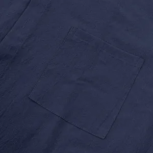 Primer plano detallado del bolsillo de una camisa de lino azul marino con textura