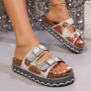 Detailopname van boheemse plateau slippers met glinsterende strass steentjes en gespen
