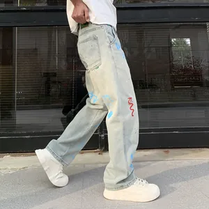 Men's loose light blue denim jeans featuring artistic graffiti prints and straight cut