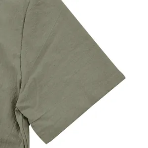 Vista detallada de la manga de una camisa de lino verde militar mostrando la textura