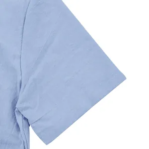 Detalle de primer plano de la manga de una camisa de lino azul claro con textura.