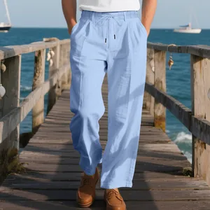 Detail of men's light blue breathable linen trousers on a seaside wooden pier.