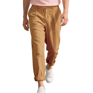 Detailed view of men's loose breathable linen trousers in tan color with drawstring waist