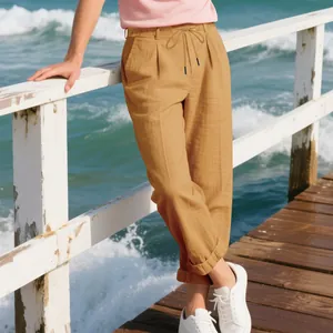 Detail of men's breathable linen trousers in khaki with drawstring waist at seaside.