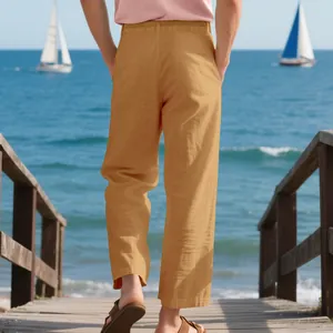 Back view of men's loose breathable yellow linen trousers in a beach setting