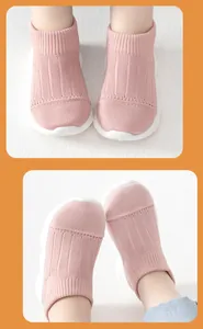 Detail view of pink knit toddler sock shoes featuring flexible white non-slip rubber soles
