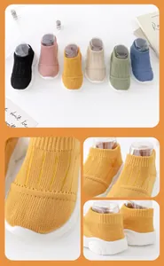 Detail view of yellow baby sock shoes showing breathable knit texture and soft sole.