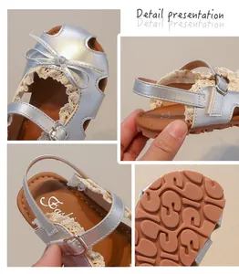 Nahaufnahme silberner Mädchensandalen mit Schleife, Spitze und rutschfester Sohle