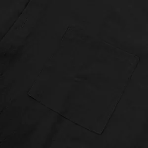Detalle macro del bolsillo del pecho y textura de lino en camisa negra casual para hombres